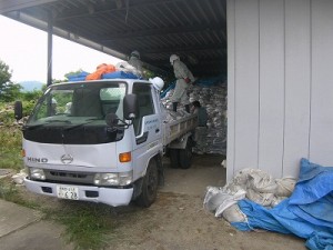 作業員が土のうを各車両に積み込む